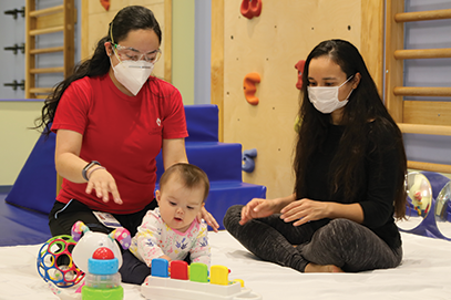 pediatric rehab therapist with infant and mom